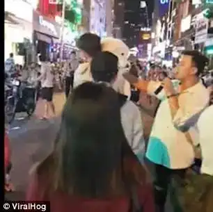 越南男子怕萨摩耶中暑深夜抱爱犬在夜市街道走